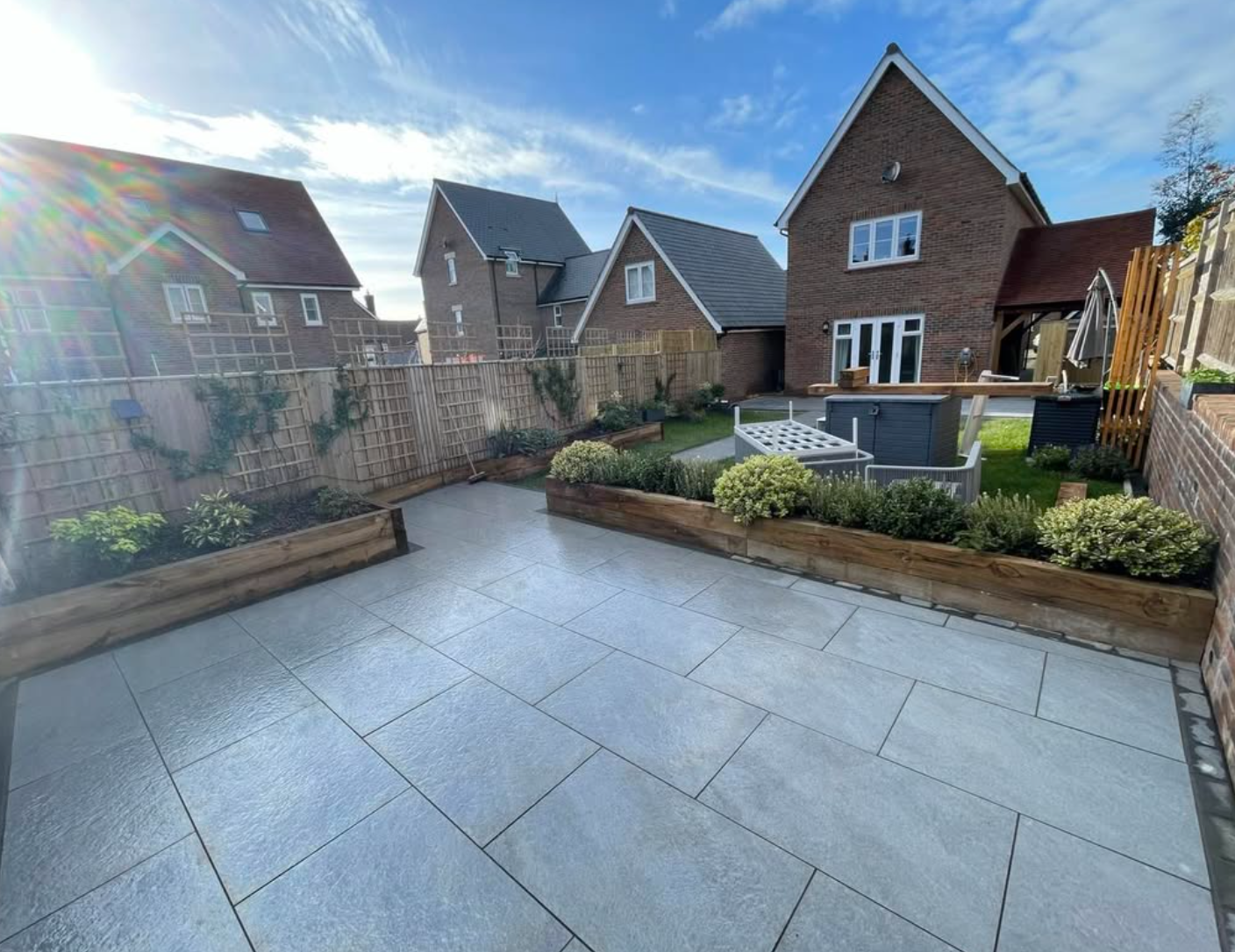 Paved garden terrace with timber-edged planting beds